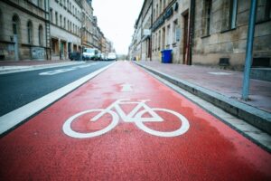 Rot markierte Radfahrspur mit weißem Fahrradsymbol in einer Stadtstraße